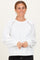 woman wearing a white sweatshirt with lace detail and puff sleeves, smiling against a neutral background