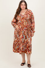 woman wearing a colorful floral print maternity dress with long sleeves and a v-neckline, showcasing her baby bump