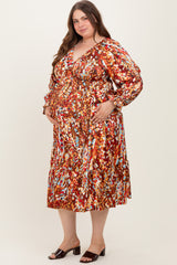woman wearing a colorful floral print maternity dress with a deep v-neck and long sleeves, showcasing her baby bump