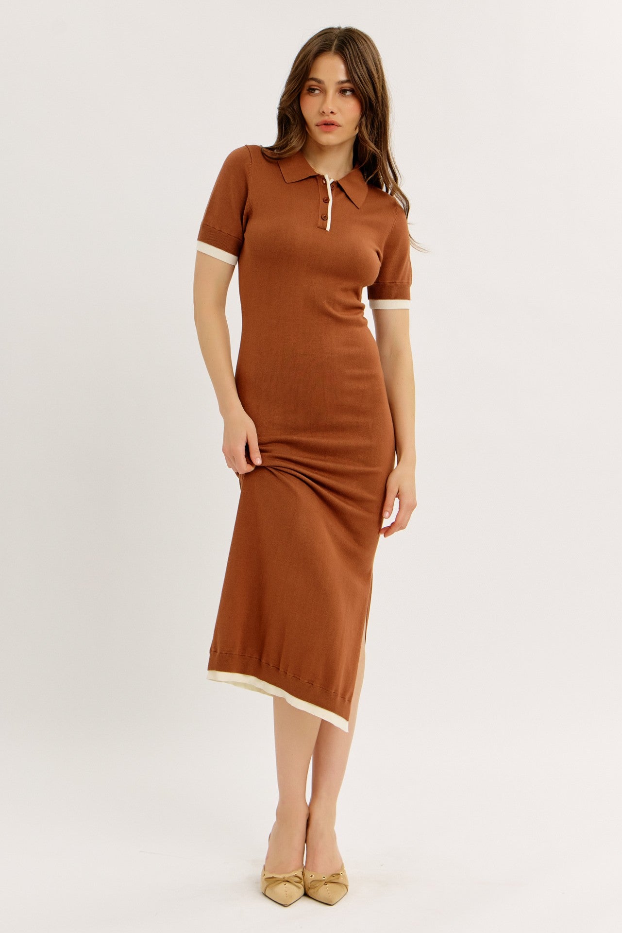 woman wearing a brown ribbed midi dress with short sleeves and a polo collar, featuring white trim at the sleeves and hem