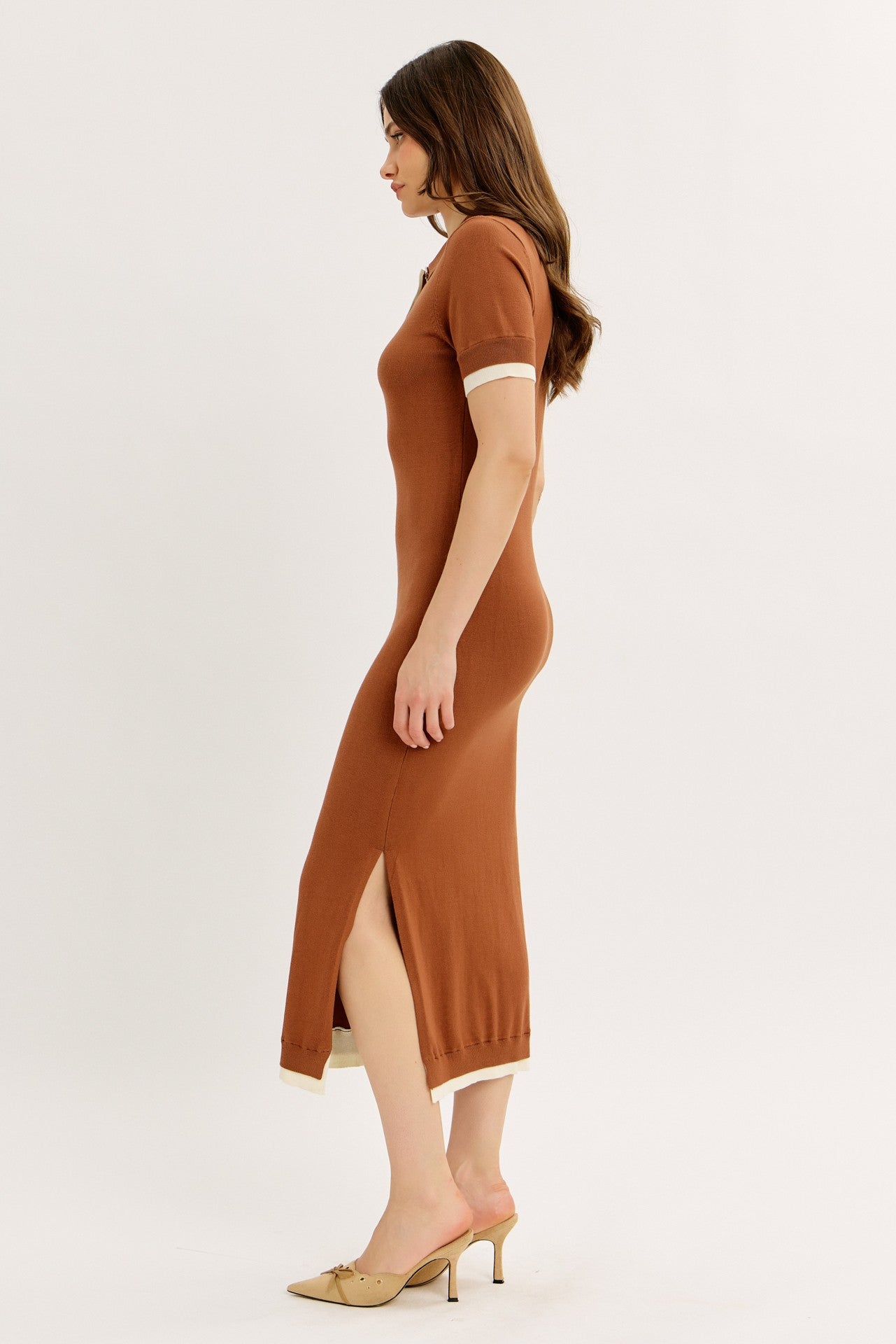woman wearing a brown ribbed knit midi dress with short sleeves and side slits, paired with beige heels