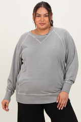 woman wearing a gray plus size sweatshirt with a relaxed fit and ribbed hem, posing with a confident expression
