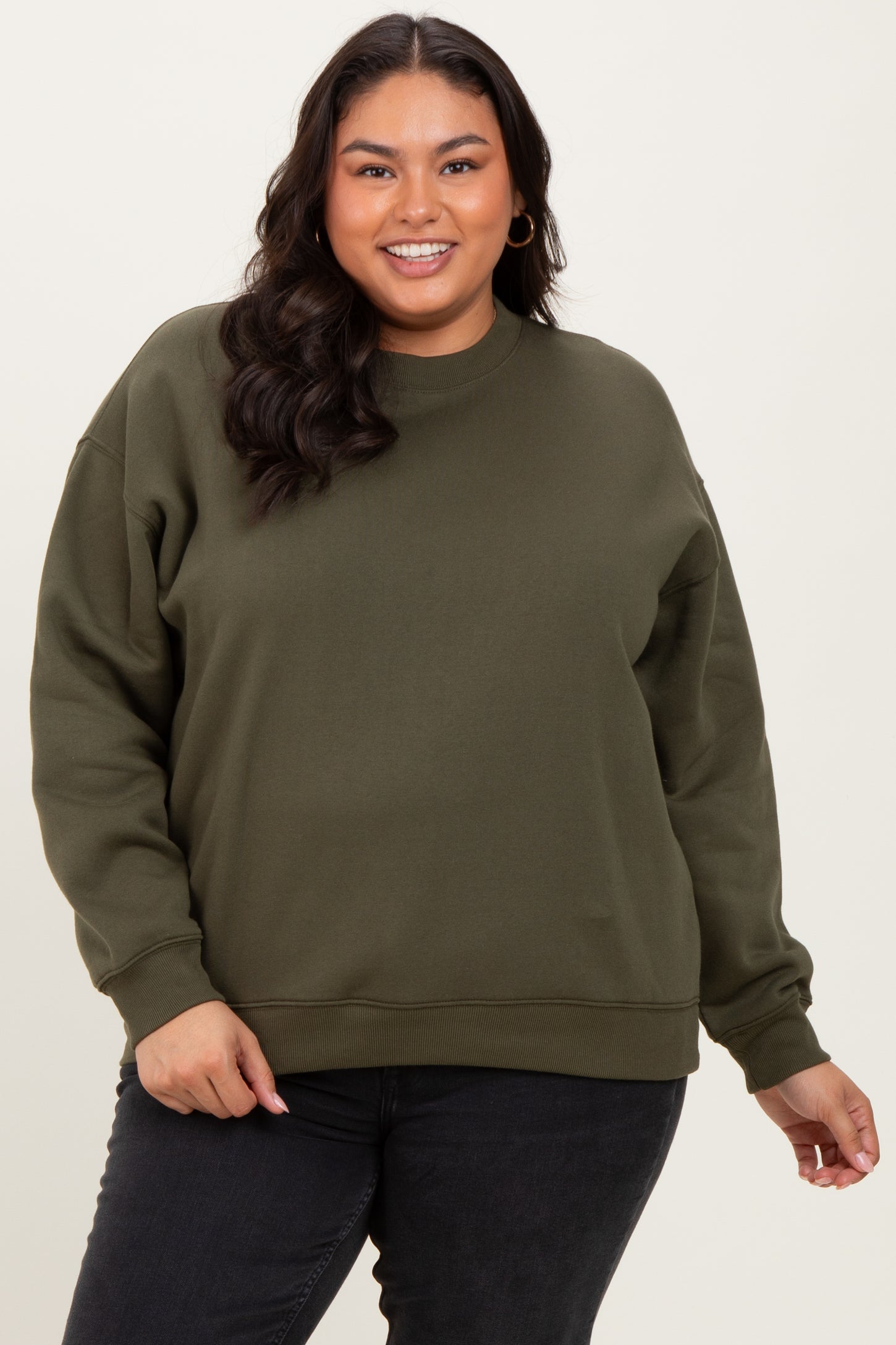 woman wearing an olive green plus size sweatshirt with a relaxed fit and long sleeves