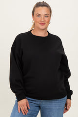 woman wearing a black maternity plus oversized sweatshirt with balloon sleeves and a baby bump visible