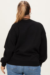 woman wearing a black oversized maternity sweatshirt from the back with long sleeves and relaxed fit