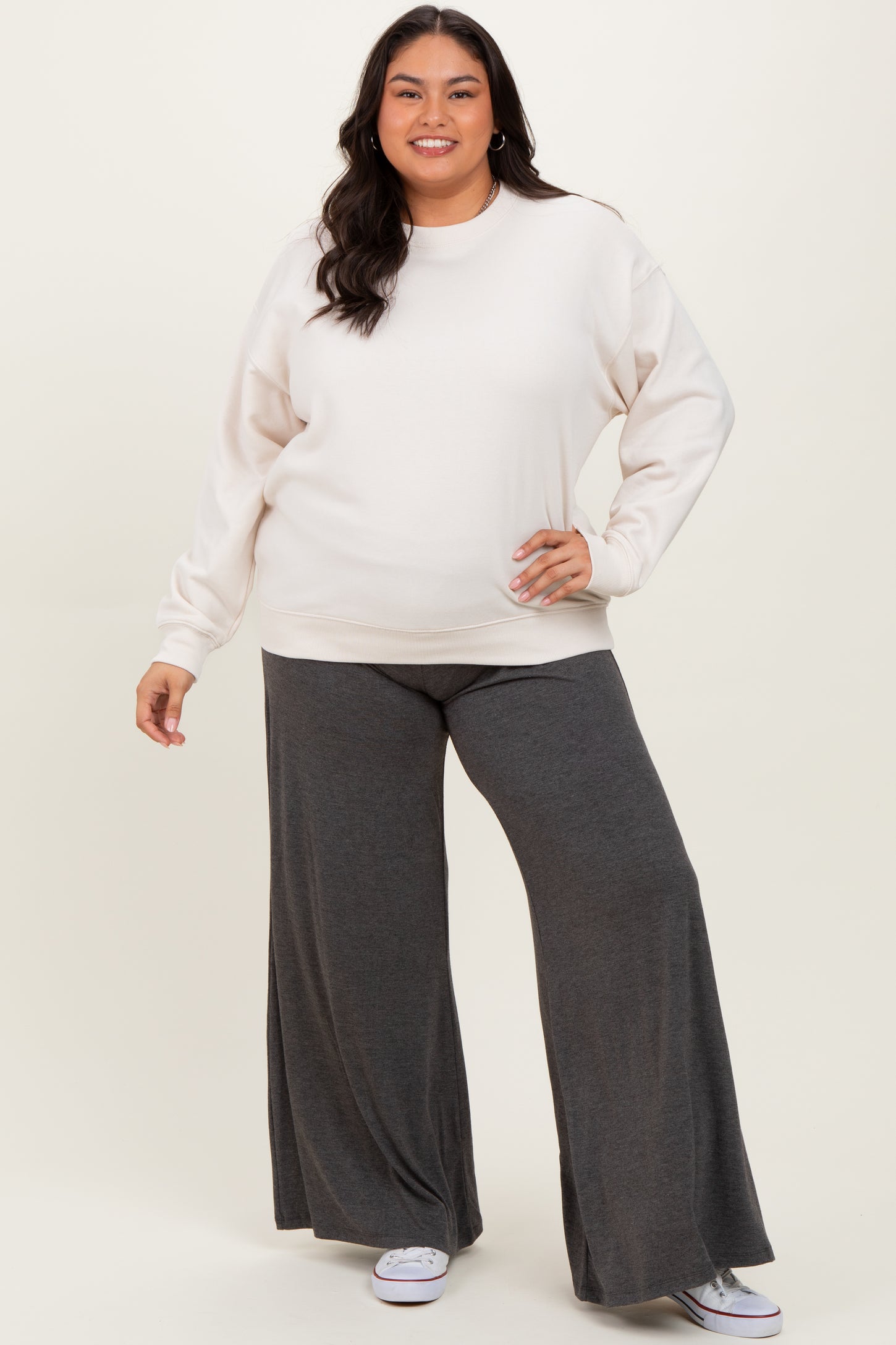 woman wearing a cream oversized sweatshirt and gray wide-leg pants