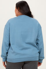 woman wearing a light blue oversized sweatshirt, view from the back, styled with gray sweatpants