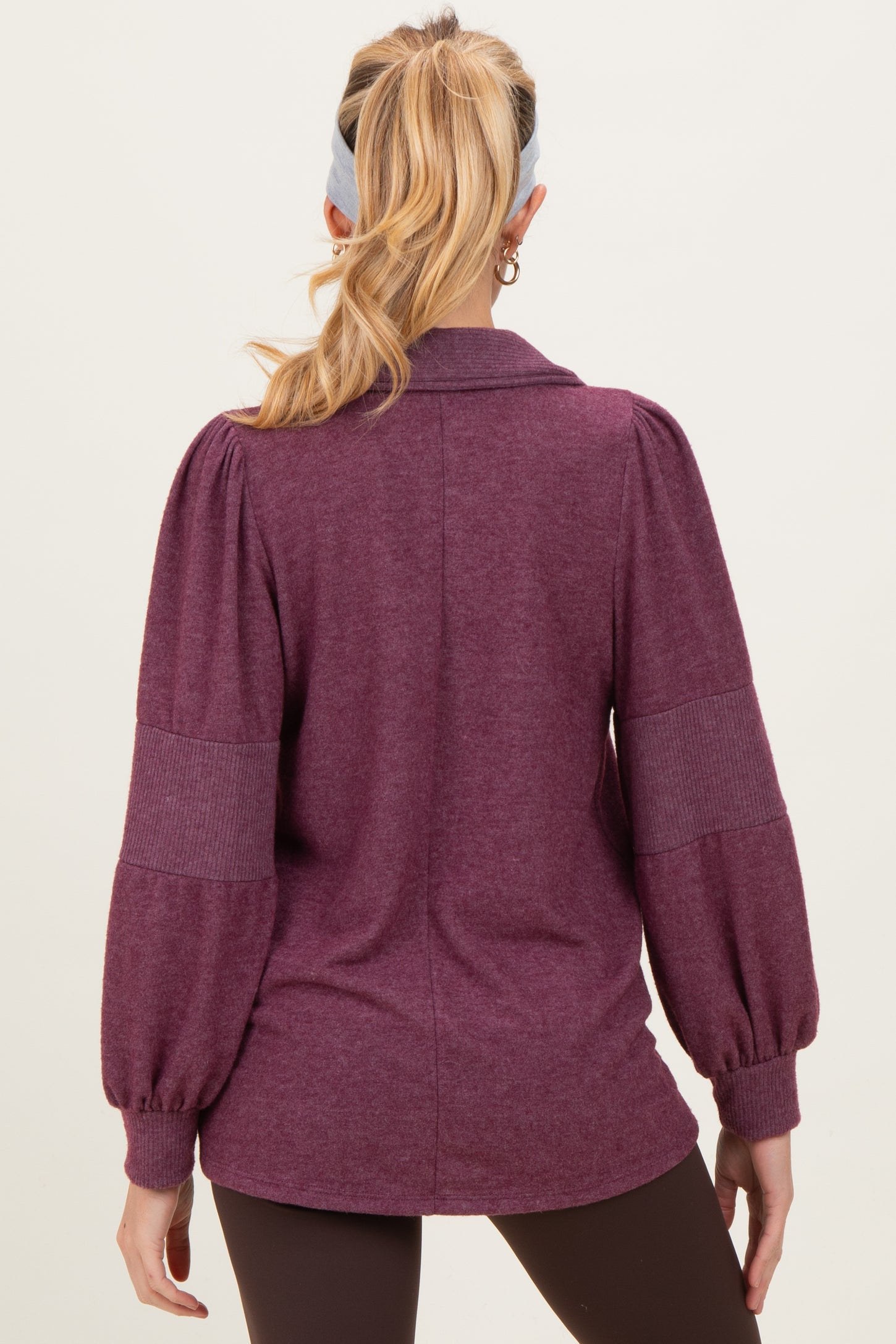 woman wearing a maroon maternity sweater with puffed sleeves, viewed from the back