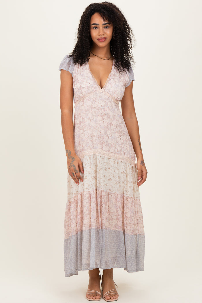 woman wearing a floral maxi dress with a v-neckline and flutter sleeves in pastel colors