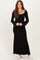 woman wearing a black long sleeve maxi dress with flared sleeves and a square neckline, styled with white sneakers