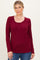 woman wearing a burgundy long sleeve henley top with button details and a scooped neckline