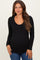 woman wearing a black long sleeve scoop neck maternity top with button detailing and a fitted style