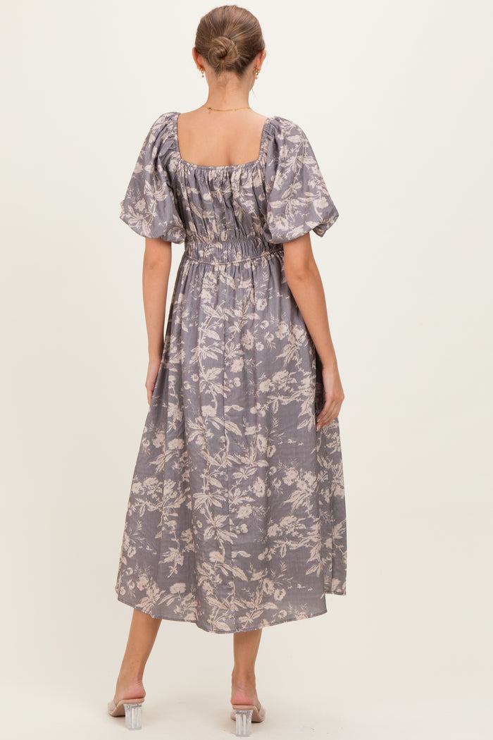 woman wearing a lavender floral maternity maxi dress with puff sleeves and a smocked back, showing a baby bump