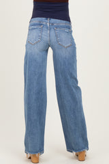 woman wearing light blue wide leg maternity jeans with a frayed hem, showing the back view