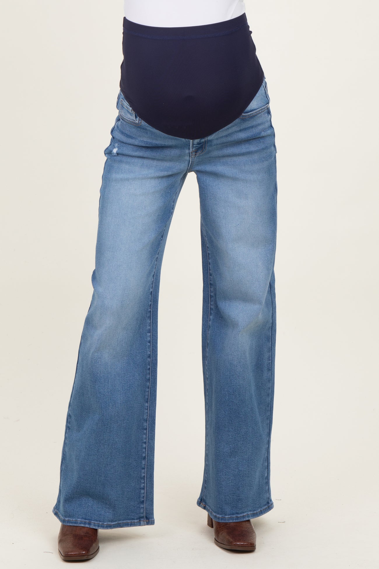 woman wearing light blue maternity flared jeans with a dark blue over-the-bump waistband