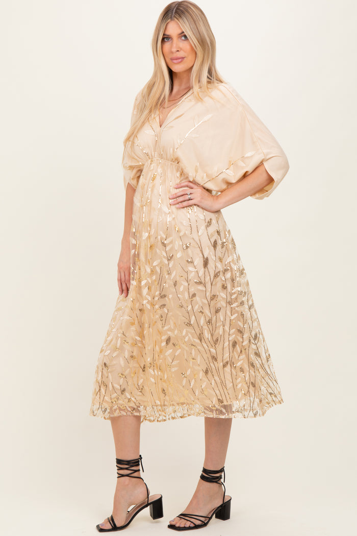 woman wearing a beige midi dress with floral embroidery and short sleeves, standing in stylish black heeled sandals