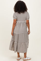 woman wearing a tiered black and white striped maxi dress with short sleeves, view from the back