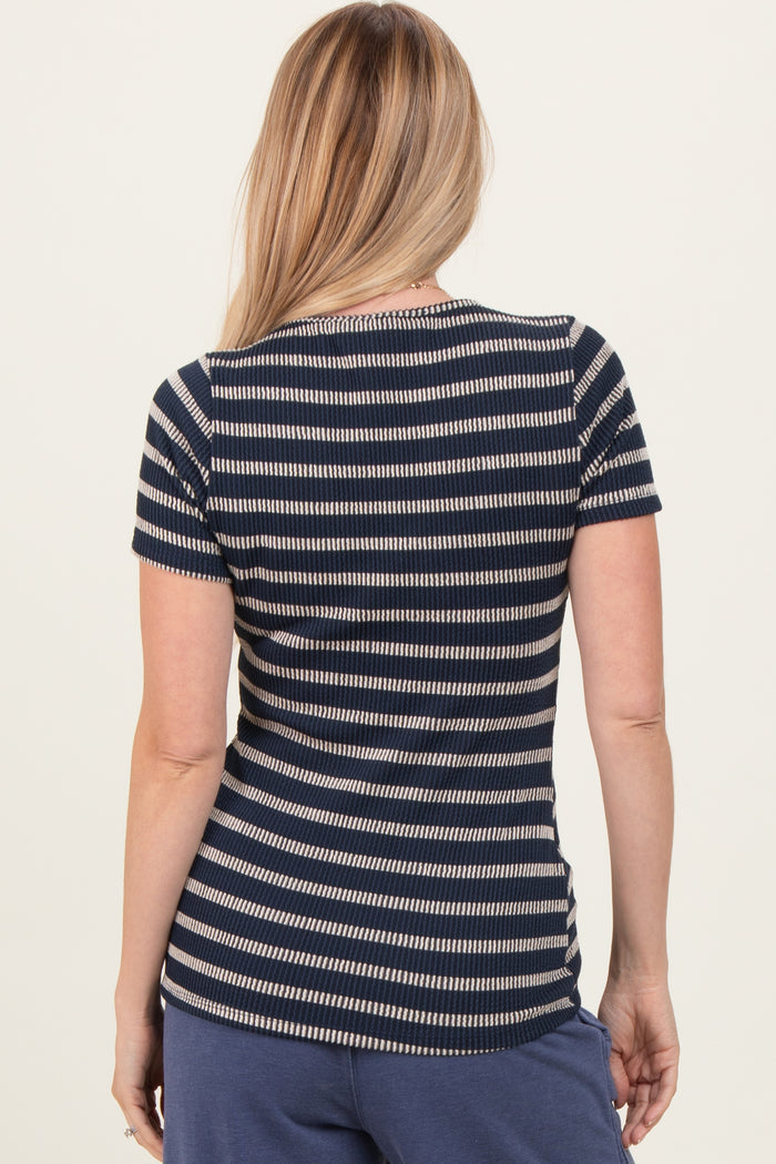 woman wearing a navy and white striped short sleeve top, viewed from the back