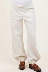 maternity wear cream oversized sweatpants with elastic cuffs, worn by a model with a visible baby bump