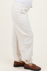 woman wearing cream-colored maternity sweatpants with elastic cuffs and side pockets