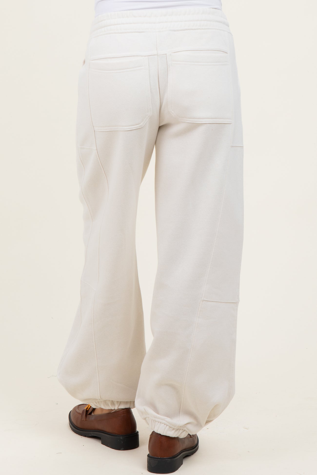 woman wearing white maternity sweatpants with a relaxed fit and elastic waistband, shown from the back