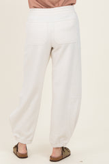woman wearing light grey cropped jogger pants with a relaxed fit and elasticized cuffs, view from the back