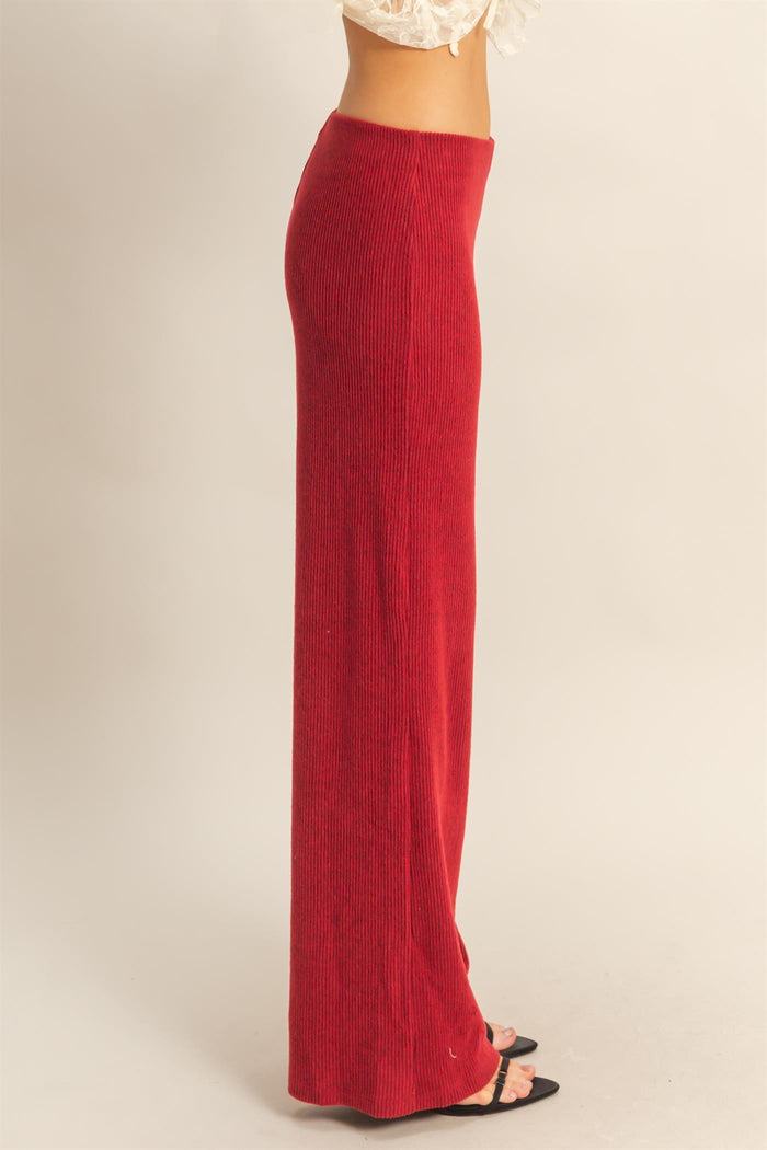 woman wearing a red ribbed maxi skirt with a stretchy waistband and a fitted silhouette, paired with black heels