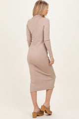 woman wearing a beige ribbed midi dress with long sleeves and a fitted silhouette, styled with tan wooden mules