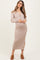 woman wearing a beige ribbed button-up maternity dress with a side slit and holding her baby bump