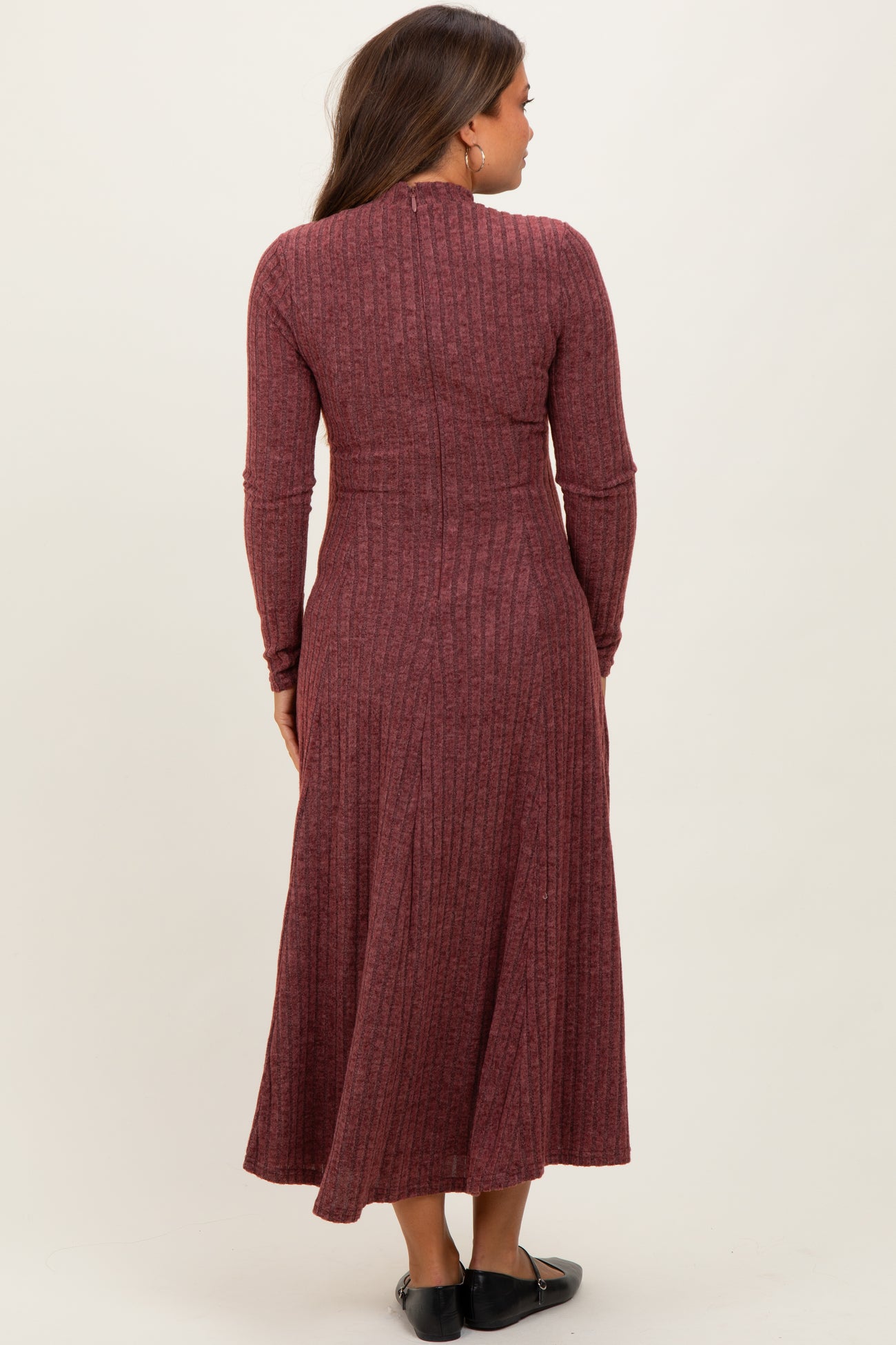 woman wearing a maroon ribbed maternity dress with long sleeves, shown from the back