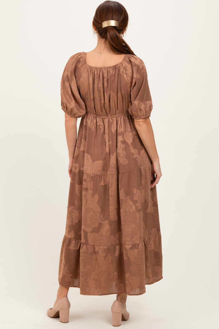 woman wearing a brown floral maxi dress with puff sleeves and a tiered skirt, viewed from the back