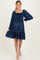 woman wearing a navy blue maternity dress with smocked bodice and flared skirt, showing off her baby bump