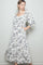 woman wearing a white floral print maxi dress with puff sleeves and side pockets