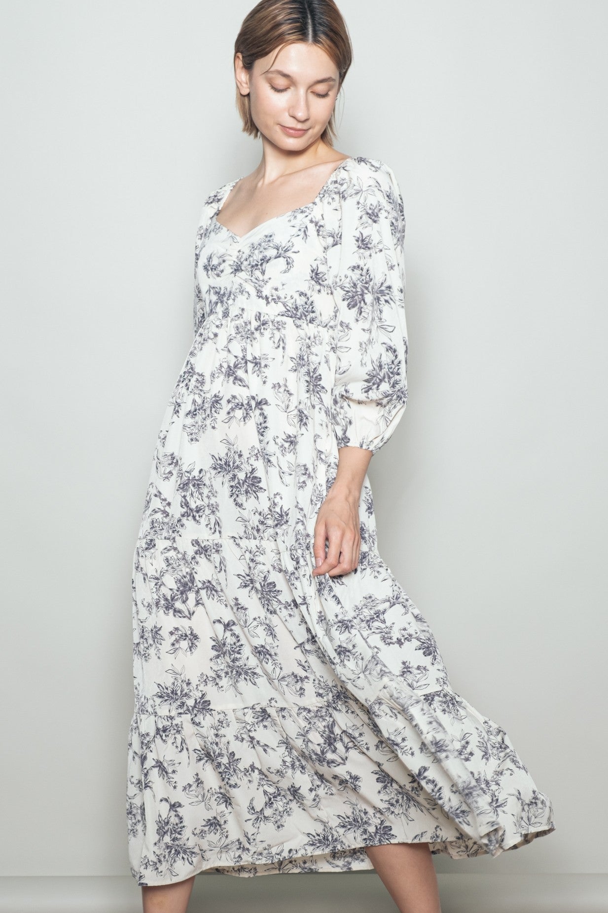 woman wearing a white floral print maxi dress with puff sleeves and a smocked bodice