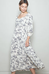 woman wearing a white floral print maxi dress with puff sleeves and a smocked bodice
