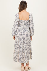 woman wearing a floral print maternity maxi dress with a smocked back and long sleeves
