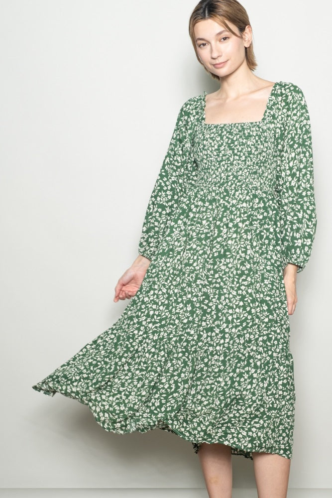 woman wearing a green floral maxi dress with a square neckline and long sleeves