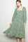 woman wearing a green floral maxi dress with a square neckline and long sleeves