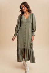 woman wearing a green long sleeve button-down dress with a tiered skirt and puffed sleeves