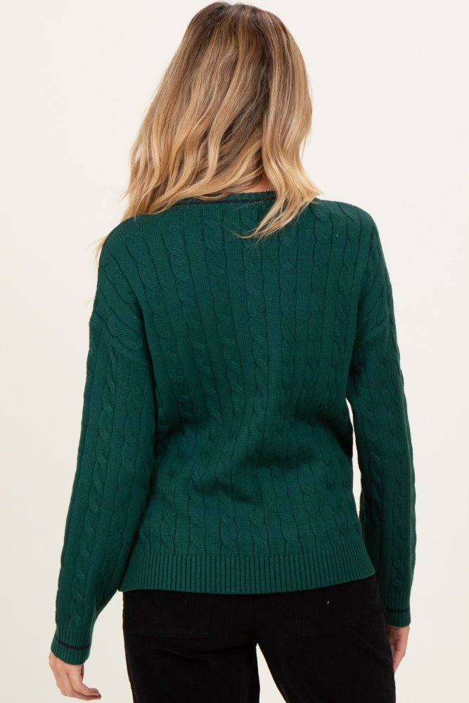 woman wearing a green cable knit maternity sweater, viewed from the back.