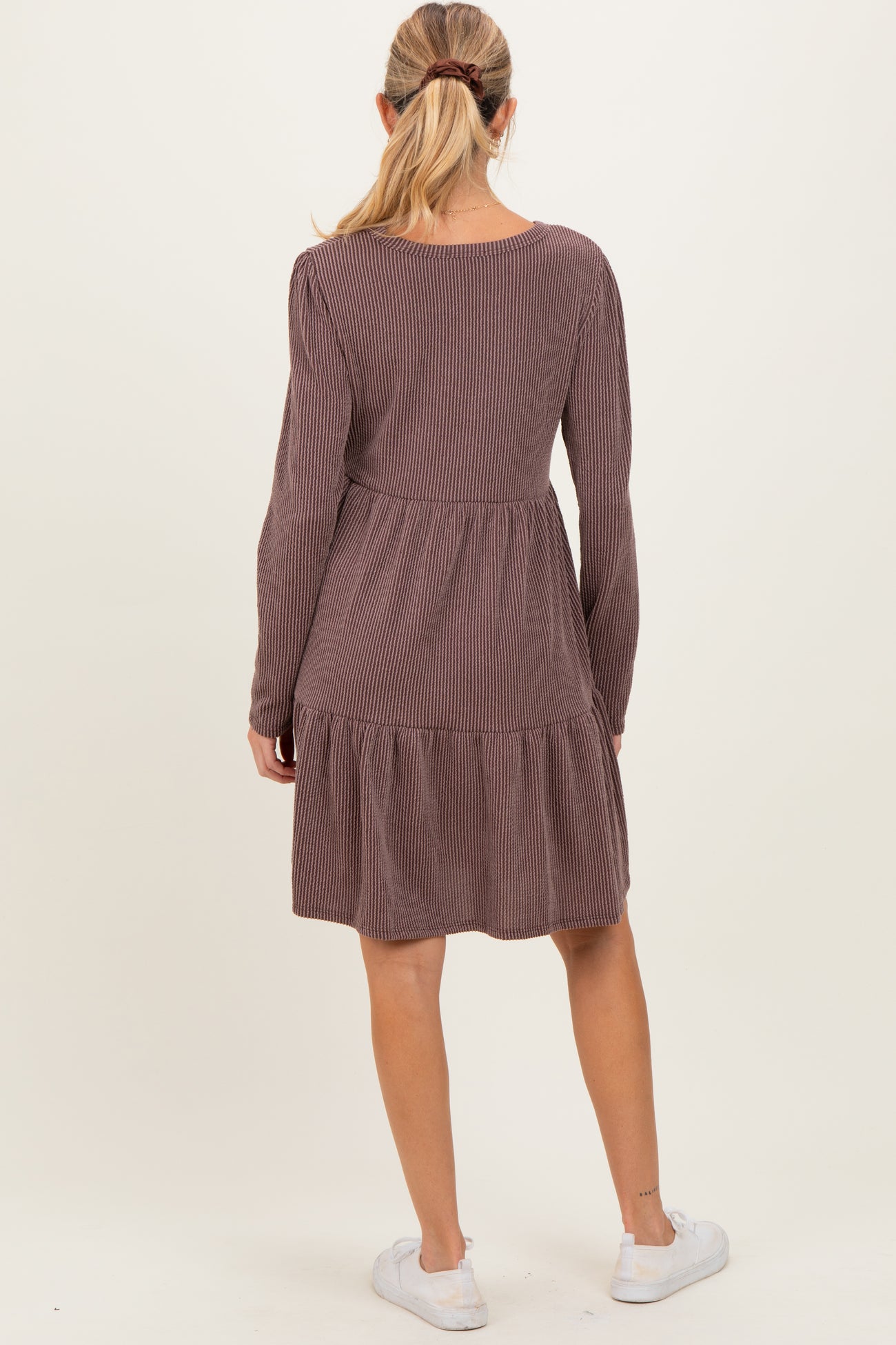 woman wearing a long sleeve striped maroon maternity dress with a tiered skirt, showing the back view