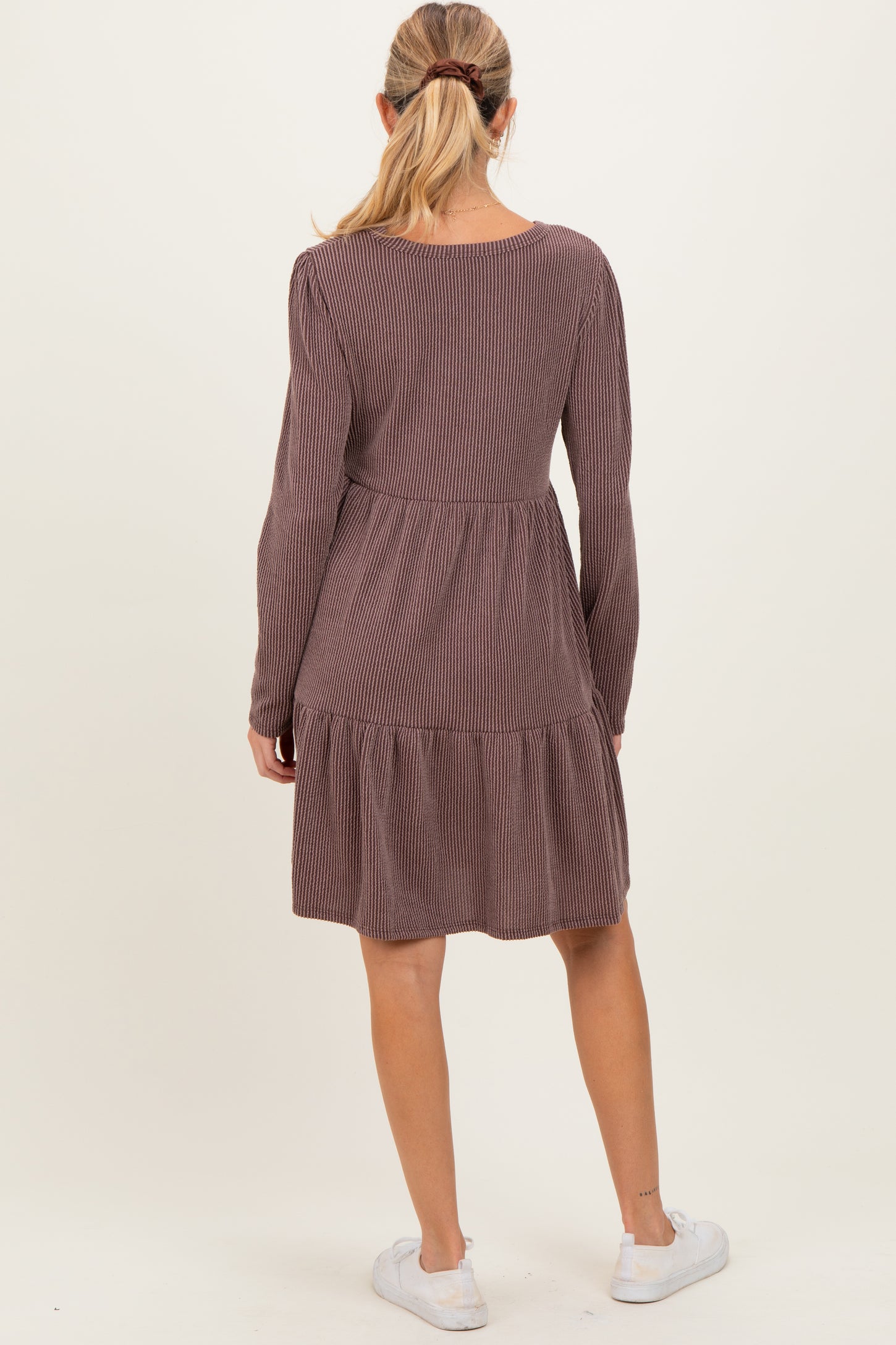 woman wearing a long sleeve striped maroon maternity dress with a tiered skirt, showing the back view