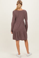 woman wearing a long sleeve striped maroon maternity dress with a tiered skirt, showing the back view