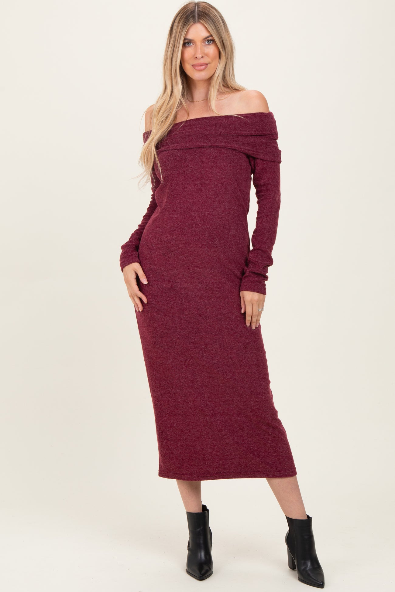 woman wearing a burgundy off-the-shoulder long sleeve dress with fitted silhouette and ribbed fabric