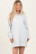 woman wearing a light gray long sleeve pullover dress with a half zipper and relaxed fit