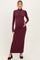 woman wearing a burgundy long sleeve maternity dress with a turtleneck and holding her baby bump