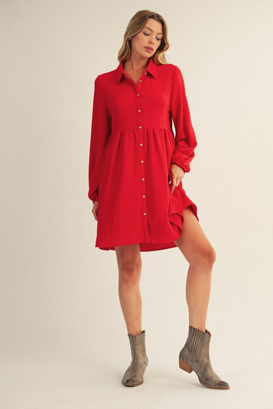 woman wearing a red button-up dress with a fitted bodice and loose skirt, paired with gray ankle boots