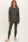 woman wearing an olive green long sleeve top and matching leggings, styled with cozy pink slipper sandals