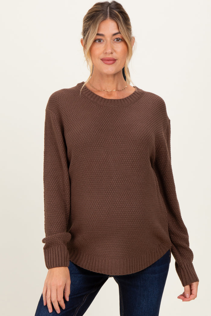 woman wearing a brown maternity sweater with a textured finish and a relaxed fit, showing her baby bump