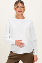 woman wearing a white lightweight maternity sweater and holding her baby bump